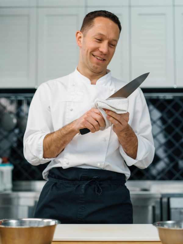 professional-kitchen-chef-wipes-clean-knife-after-cooking-breakfast-healthy-food-concept.jpg